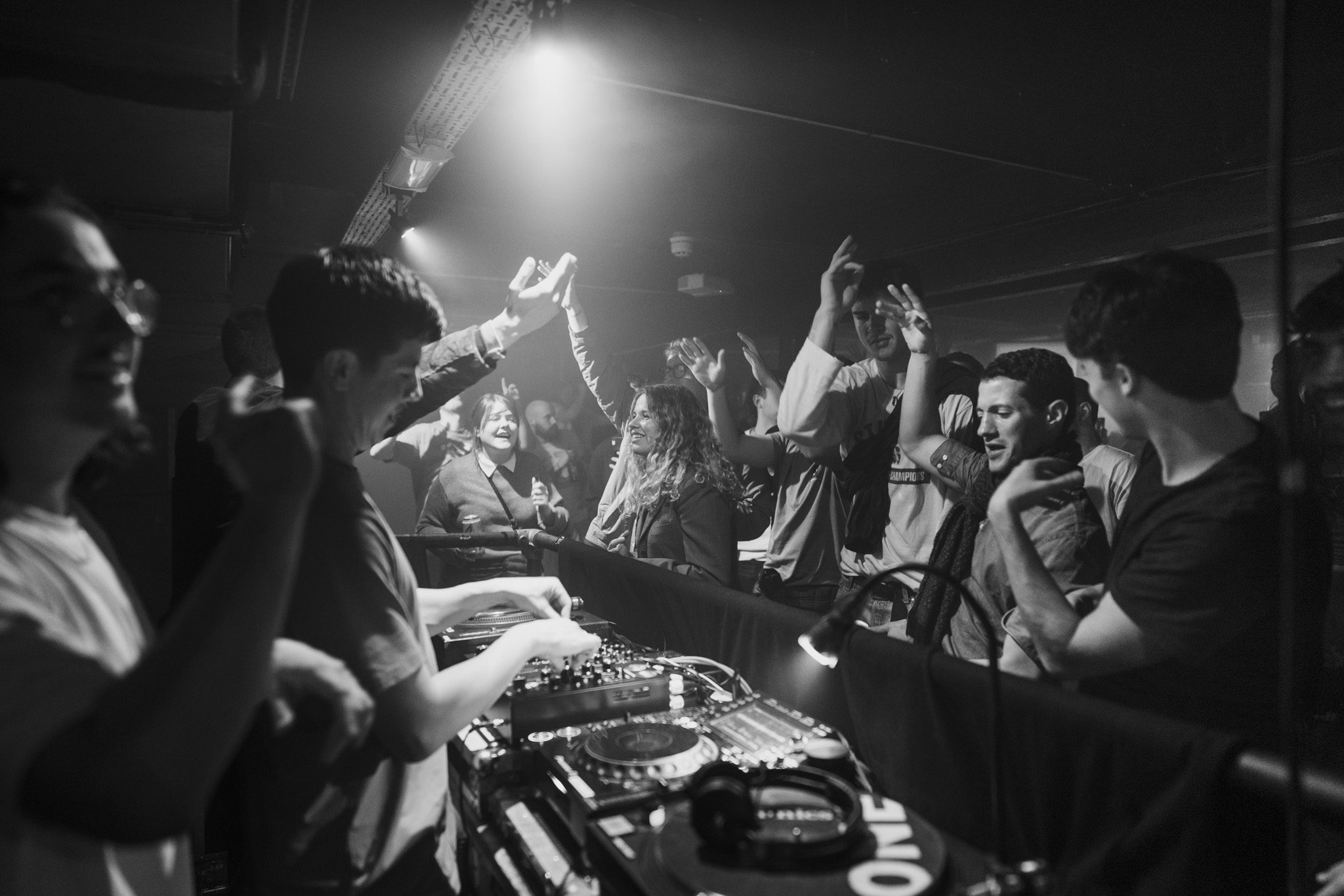 A crowded club night at Soulsville, Edinburgh, in black and white, the DJ at the decks