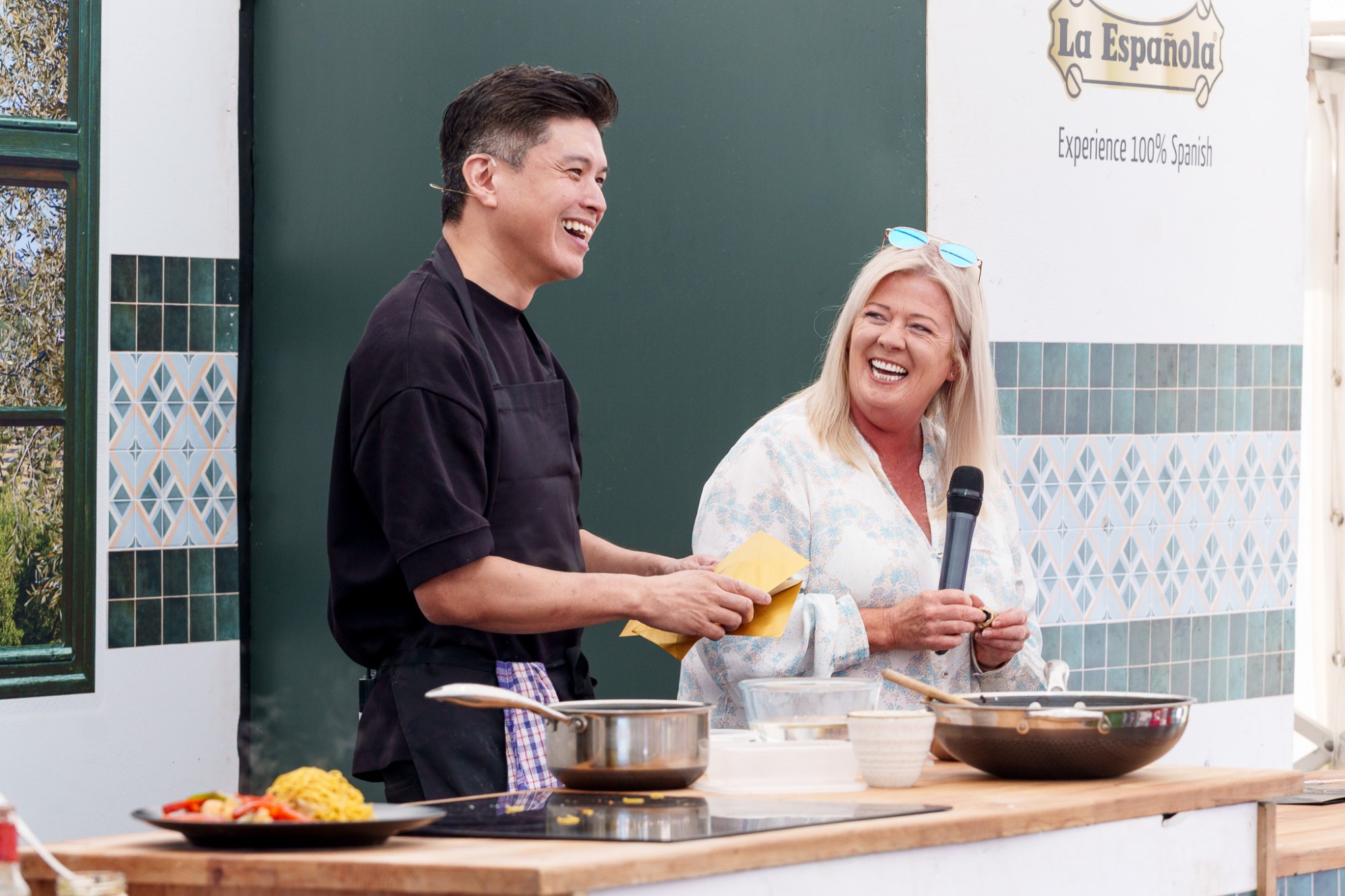 A chef and a host laughing together at a cookery demonstration at Foodies Festival, Glasgow