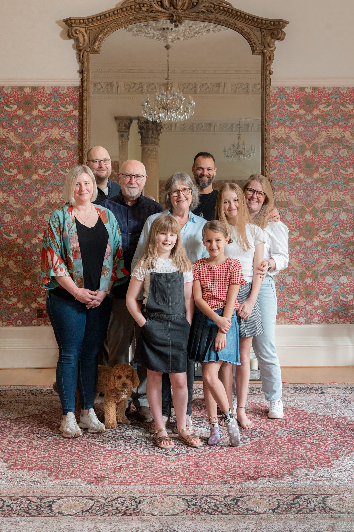A family of three generations in a room with a gilded mirror