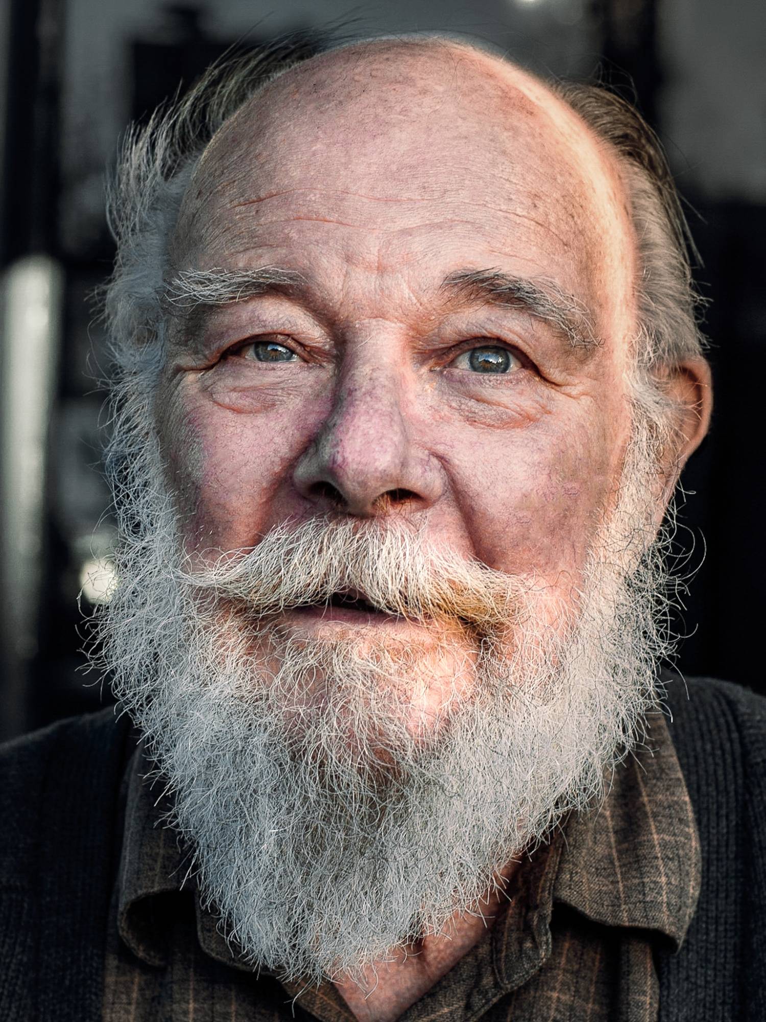 An older man with a white beard, looking just past the camera