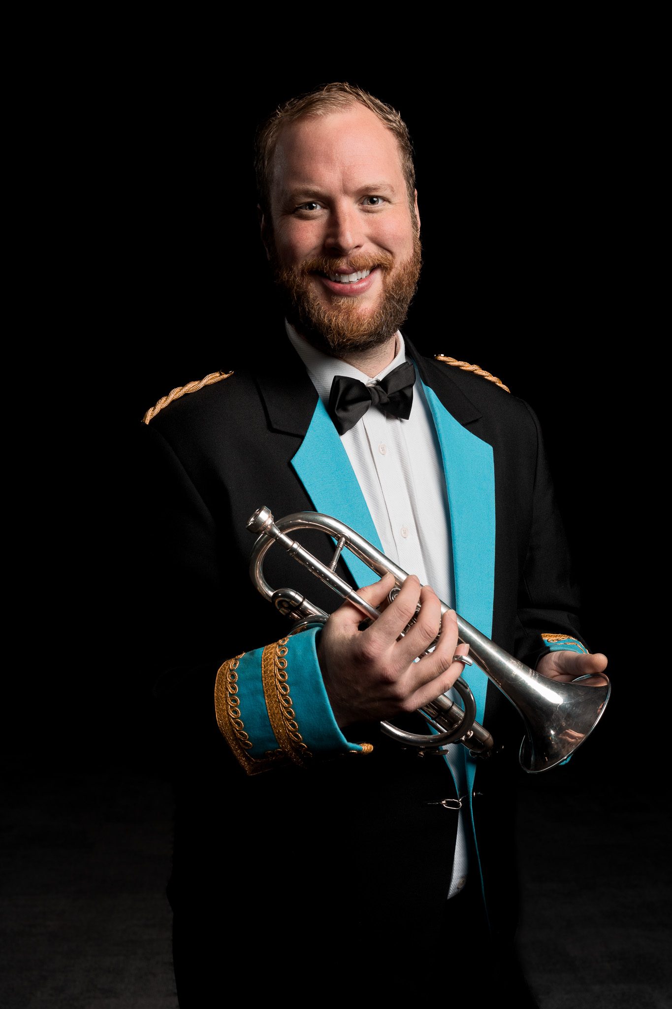 A smiling brass band player holding a cornet